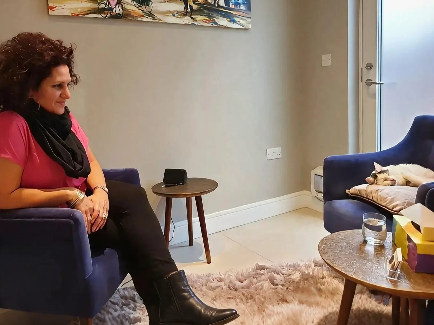 Lynda in her counselling room, with her cat asleep on the chair opposite